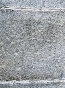 Close up of a yellowish grey building stone with laminations